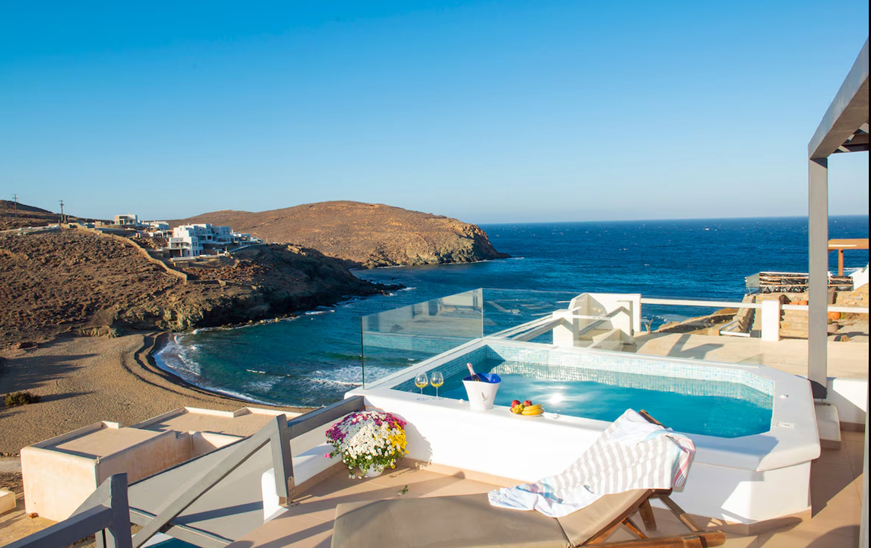 A private terrace with a plunge pool overlooking a sandy bay on the Mykonos coast